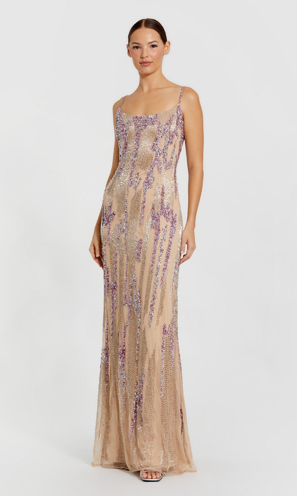 A woman wears the Mac Duggal 6150 long formal dress in nude, a sleeveless floor-length gown with sequin mesh and sparkling purple and silver beaded embellishments, standing against a plain light background.